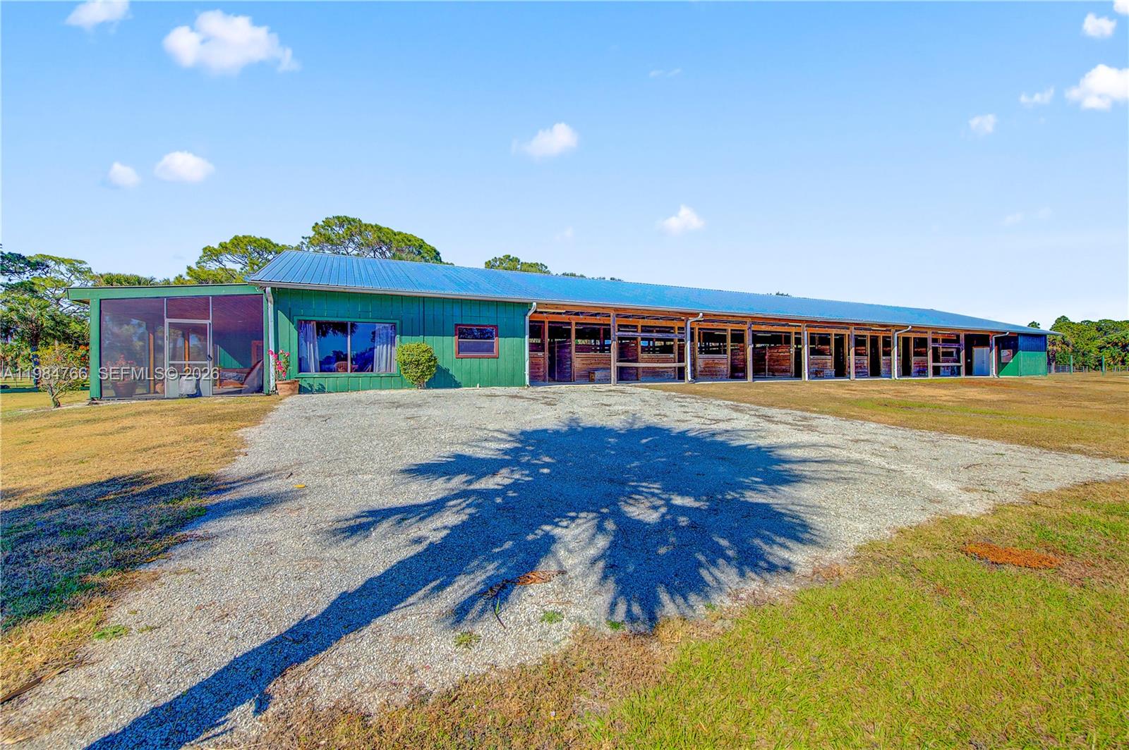 A long green barn with a metal roof and a screened-in porch area — 30003 SW Martin Hwy, Okeechobee FL 34974, OKEECHOBEE, FL