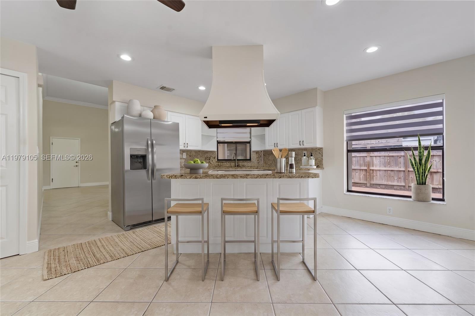 A kitchen features white cabinets, granite countertops, a central island with bar stools, and stainless-steel appliances — 536 SW 88th Ct, Miami FL 33174, MIAMI, FL