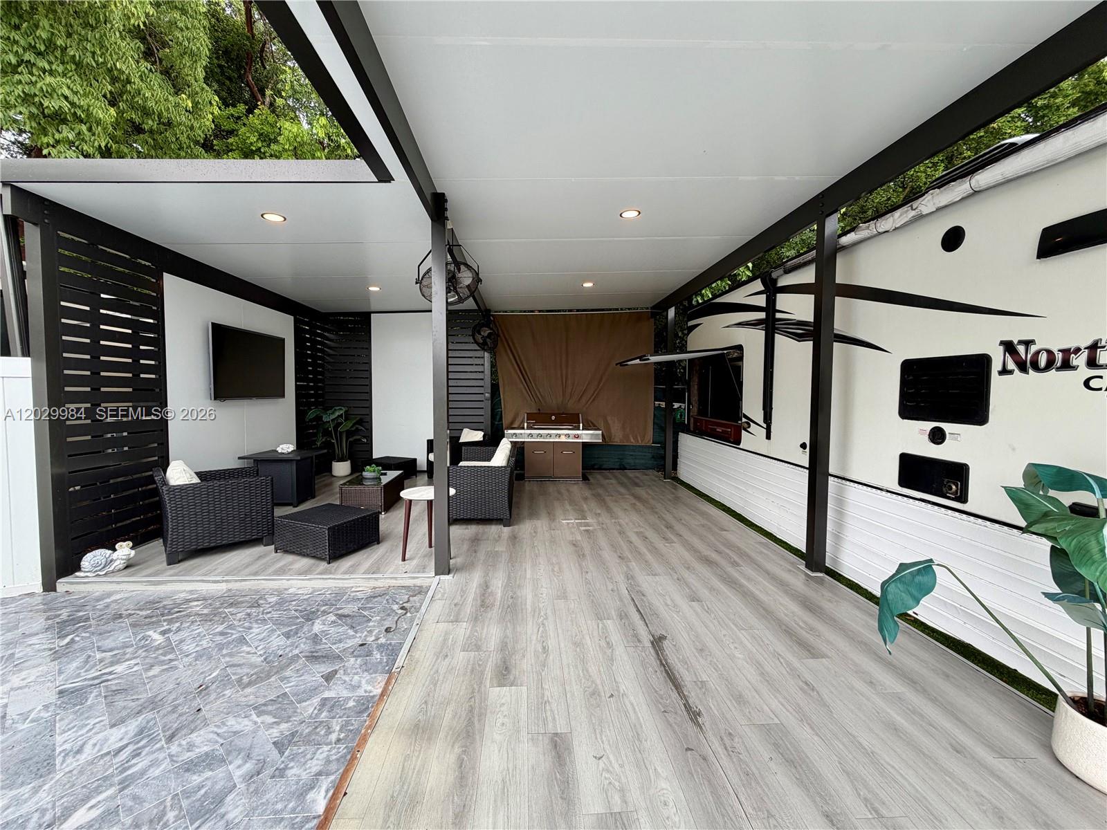 A covered outdoor patio features wood-look flooring, a seating area, a grill, and a parked RV — 325 Calusa St #122, Key Largo FL 33037, KEY LARGO, FL