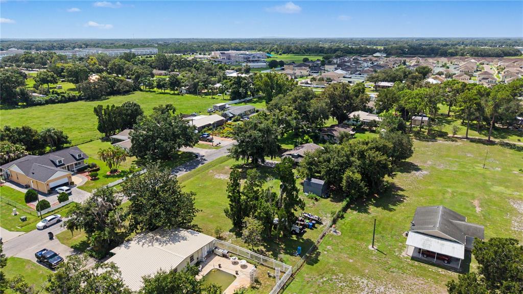 An aerial view shows several houses, large grassy lots, and mature trees in a neighborhood — 3015 DER ROAD, PLANT CITY, FL