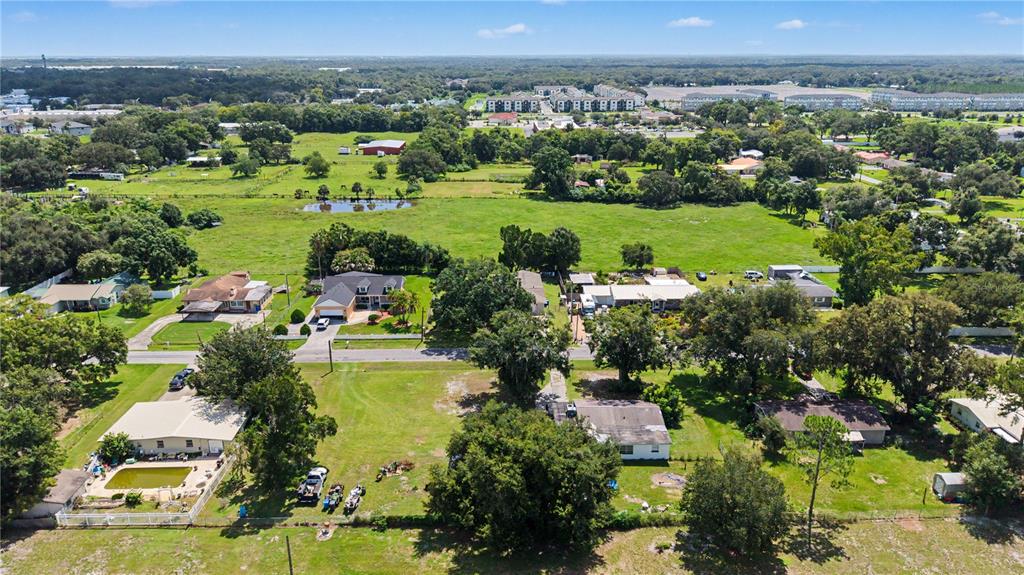 An aerial view shows several houses with large yards and trees in a rural setting — 3015 DER ROAD, PLANT CITY, FL
