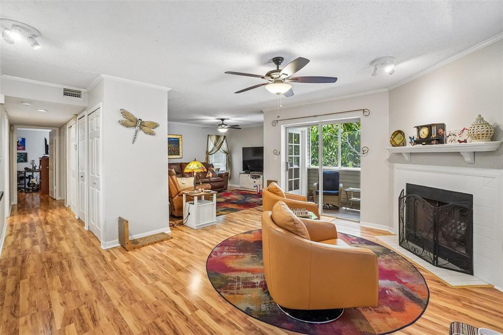 A living room features a fireplace, two tan armchairs on a rug, and wood flooring — 8350 SAVANNAH TRACE CIRCLE UNIT 1601, TAMPA, FL
