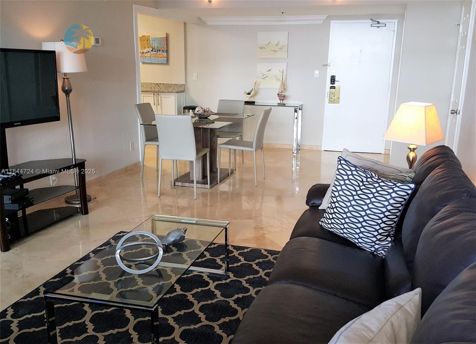 A living room and dining area feature tile flooring, a glass coffee table, and dark furniture — 5225 Collins Ave # 510, Miami Beach FL 33140, MIAMI BEACH, FL