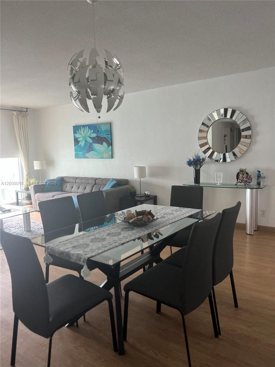 A dining area with a glass table and chairs sits in front of a living room — 3901 S Ocean Dr # 14T, Hollywood FL 33019, HOLLYWOOD, FL