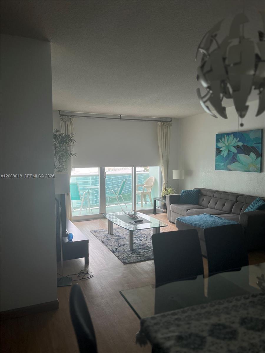 A living room features a gray sectional sofa, glass coffee table, and a balcony view — 3901 S Ocean Dr # 14T, Hollywood FL 33019, HOLLYWOOD, FL