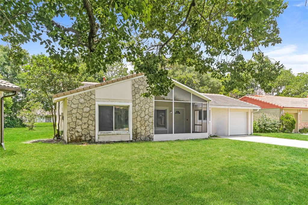 A single-story house with a stone facade, a screened-in porch, and a two-car garage — 10346 MATCHLOCK DRIVE, ORLANDO, FL
