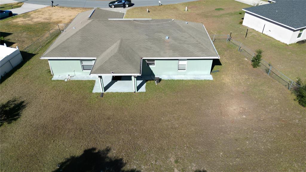 An aerial view of a single-story house with a green exterior and a shingled roof — 3648 SW 131ST PLACE ROAD, OCALA, FL