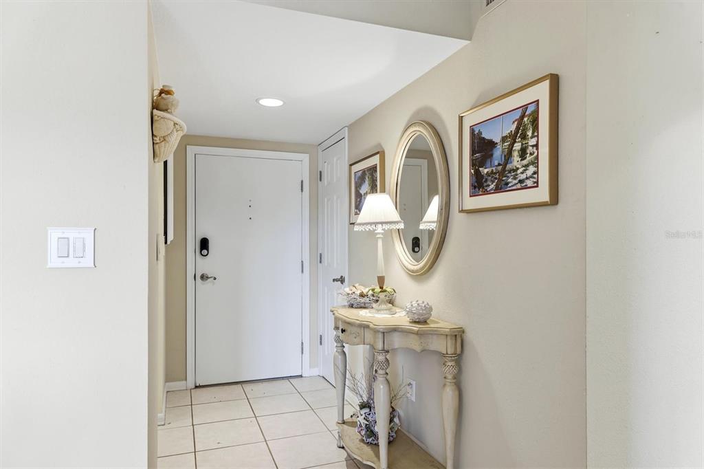 An exterior walkway with a white railing overlooks a parking area and palm trees — 1215 S PORTOFINO DRIVE UNIT 406, SARASOTA, FL