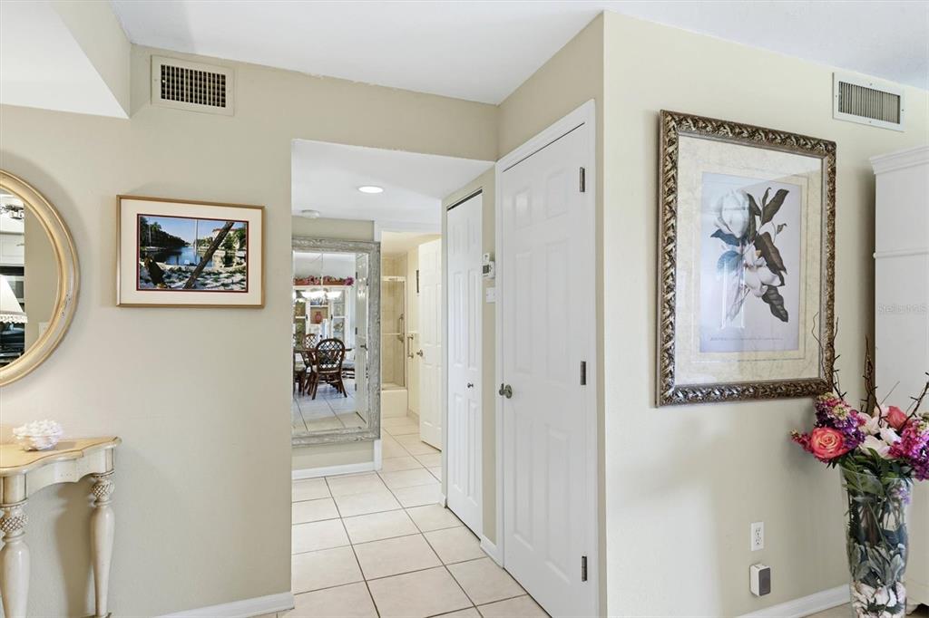 An entryway features a white door, a console table with a lamp, and a mirror — 1215 S PORTOFINO DRIVE UNIT 406, SARASOTA, FL