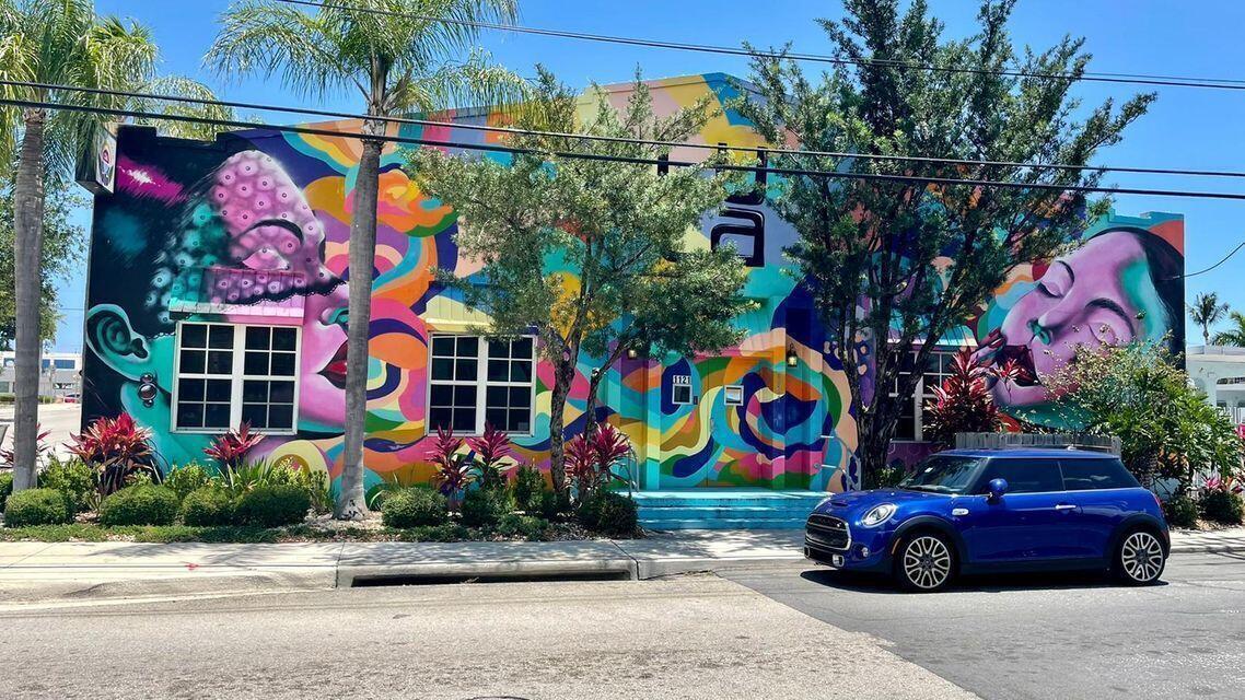 A vibrant, colorful mural covers the exterior facade of a building with a blue car parked — 1202 S M Street, FL 33460, FL