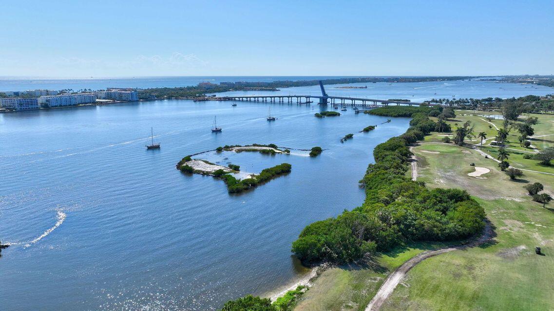An aerial view shows a bridge over water, a small island, and a coastal golf course — 1202 S M Street, FL 33460, FL