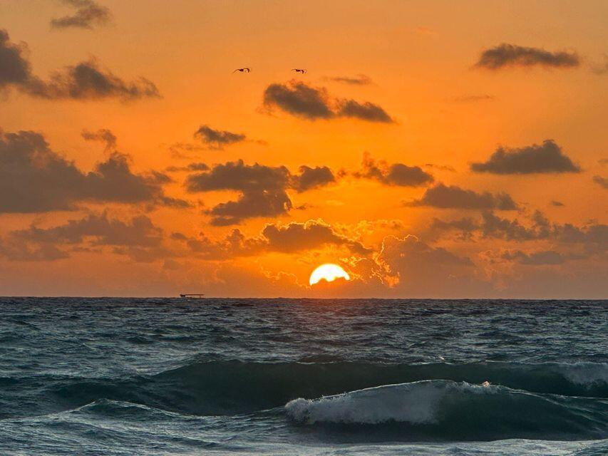 A sunset over the ocean with clouds in an orange sky and a breaking wave — 1202 S M Street, FL 33460, FL