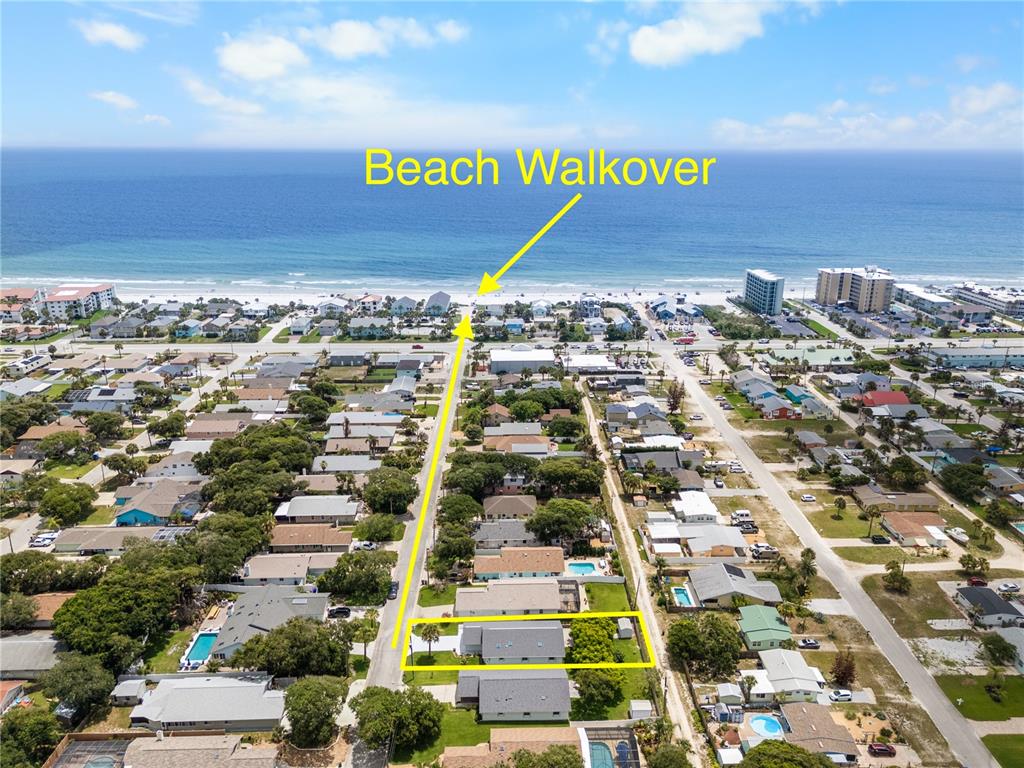 An aerial view shows a residential property with a highlighted path to the beach — 815 E 23RD AVENUE, NEW SMYRNA BEACH, FL