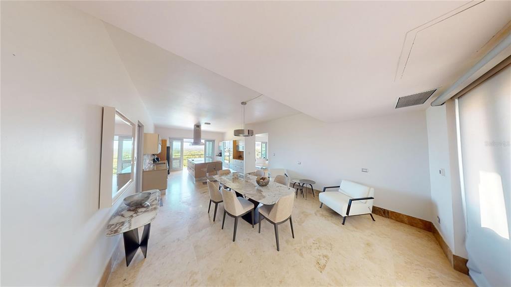 A dining area with a marble table and chairs, adjacent to a kitchen and living space — 52 LAS VISTAS DE RIO MAR, RIO GRANDE, PR