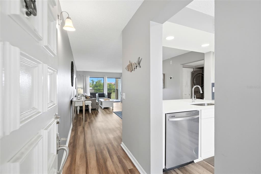 An entryway leads into a living room with wood-look flooring and an adjacent kitchen area — 6105 PALMA DEL MAR BOULEVARD S UNIT 219, ST PETERSBURG, FL