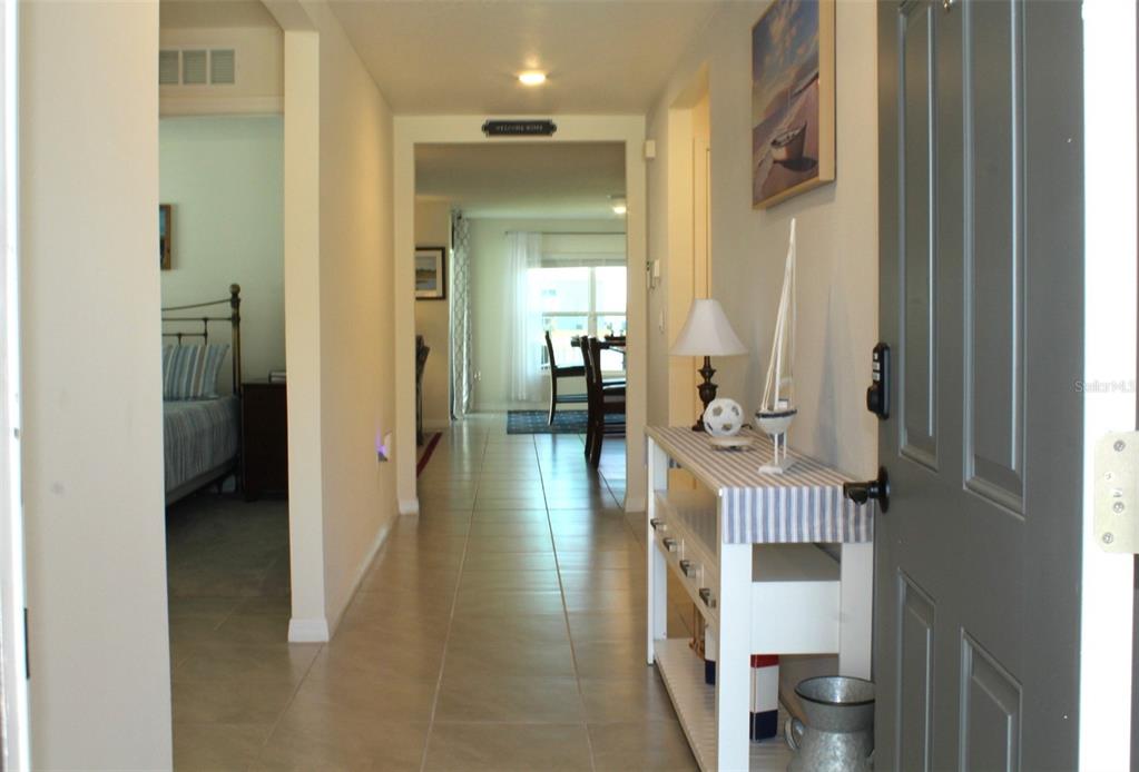 A view from an entryway looking down a tiled hallway toward a dining area — 810 WILL SCARLETT AVENUE, RUSKIN, FL