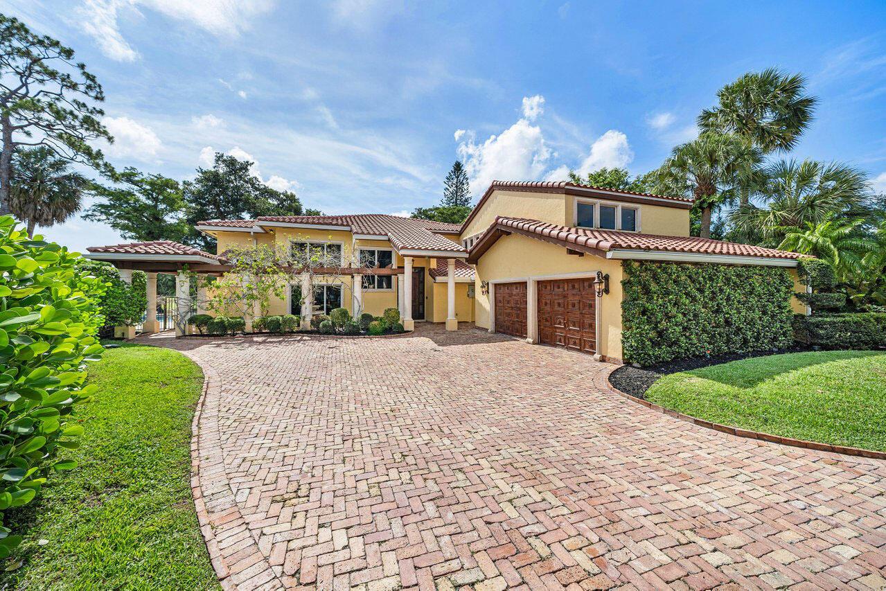 A yellow two-story house with a brick driveway, tile roof, and a two-car garage — 6541 Timber Lane, Boca Raton FL 33433, BOCA RATON, FL