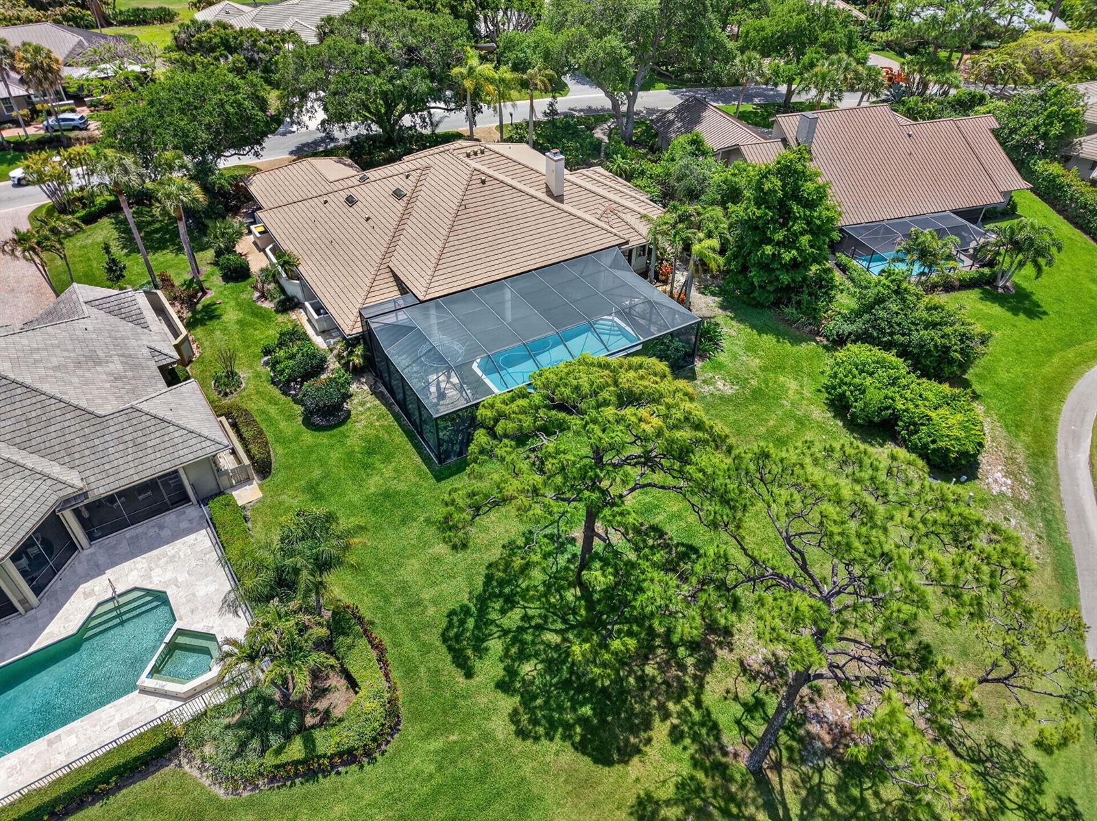 An aerial view shows a house with a screened-in pool and a large backyard — 6460 SE Winged Foot Drive, Stuart FL 34997, STUART, FL