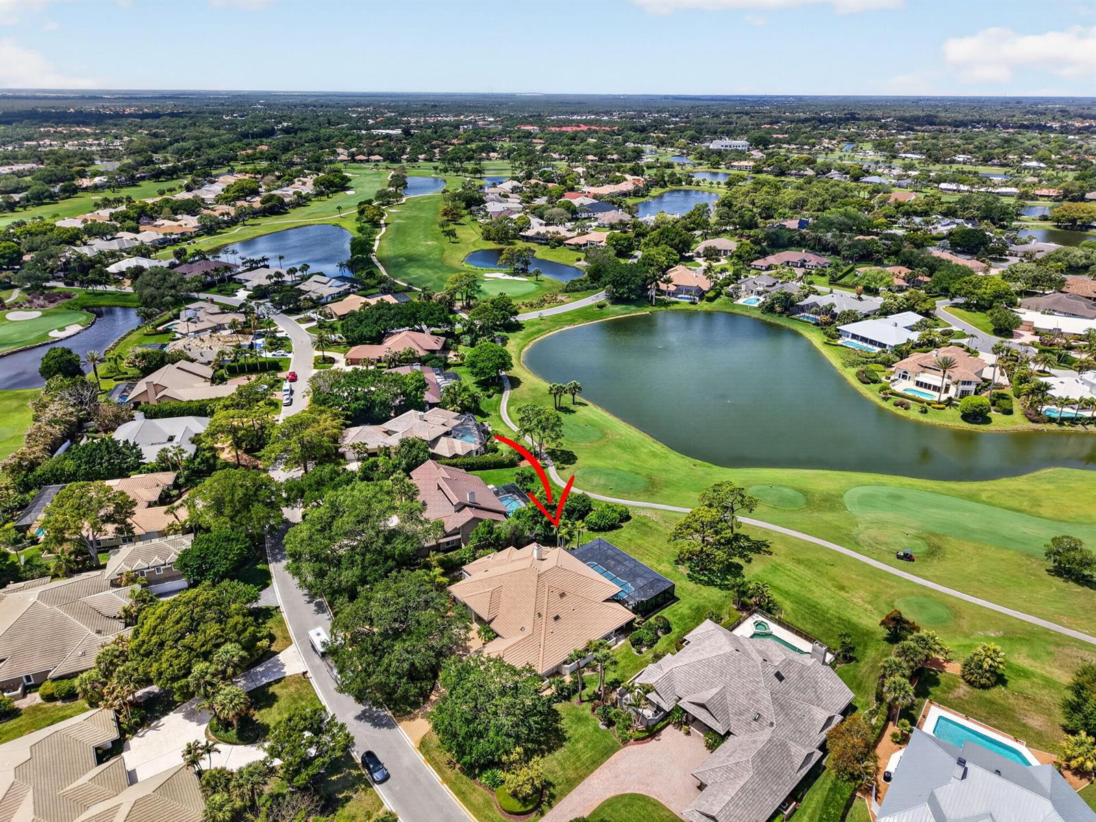 An aerial view shows a residential house with a pool cage overlooking a golf course — 6460 SE Winged Foot Drive, Stuart FL 34997, STUART, FL