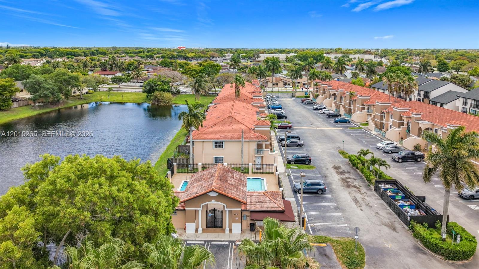 An aerial view shows a multi-unit residential complex with a pool and adjacent lake — 6466 SW 130th Pl # 902, Miami FL 33183, MIAMI, FL