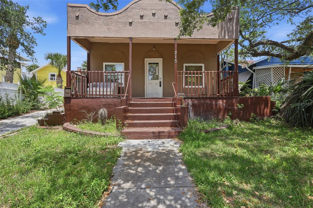 A brown, single-story house with a front porch, steps, and a concrete walkway — 215 S OLEANDER AVENUE, DAYTONA BEACH, FL