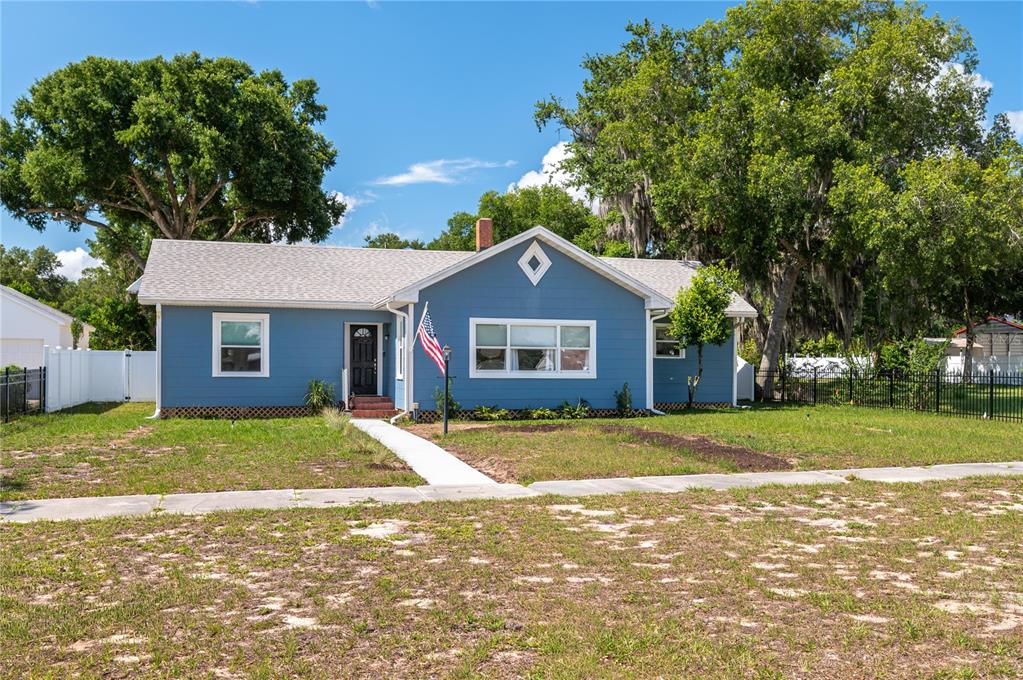 A blue, single-story house with a white roof and a front yard with trees — 414 E BULLARD AVENUE, LAKE WALES, FL