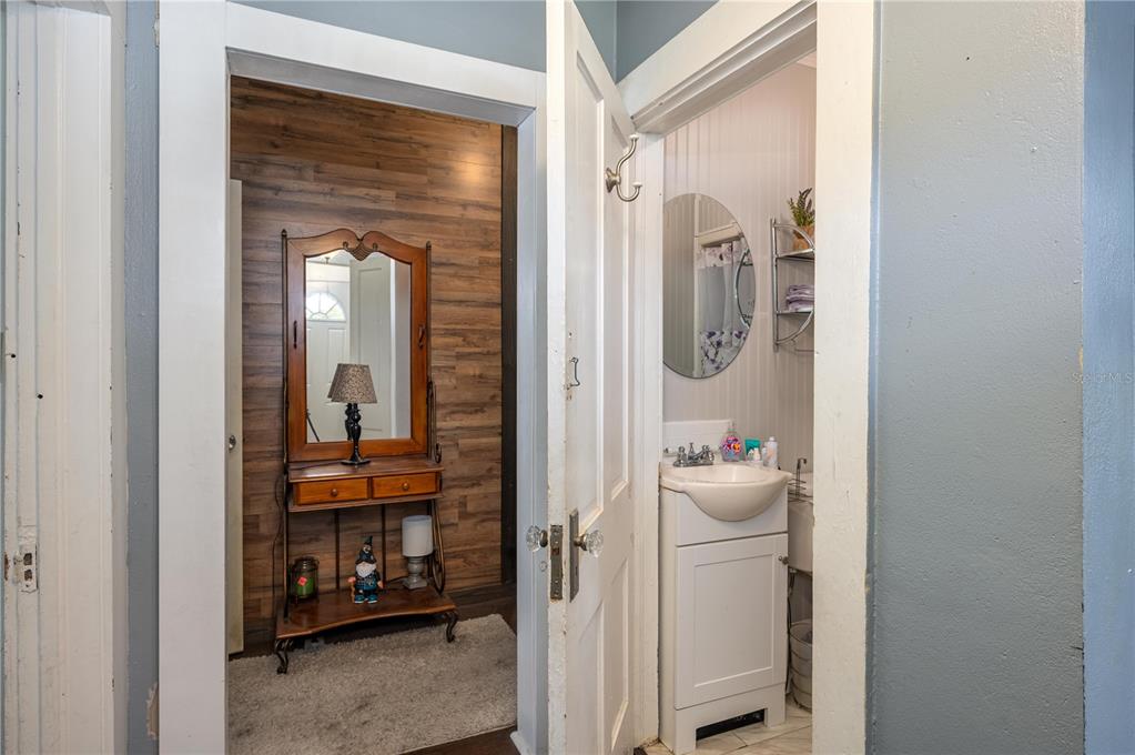 A view through an open door shows a small bathroom next to a wood-paneled entryway — 414 E BULLARD AVENUE, LAKE WALES, FL