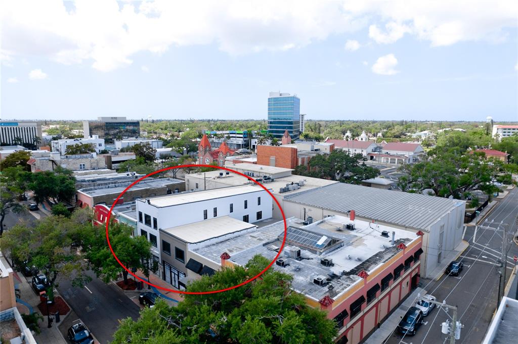 An aerial view shows a multi-story commercial building with a flat roof in a city — 420 12TH STREET W, BRADENTON, FL