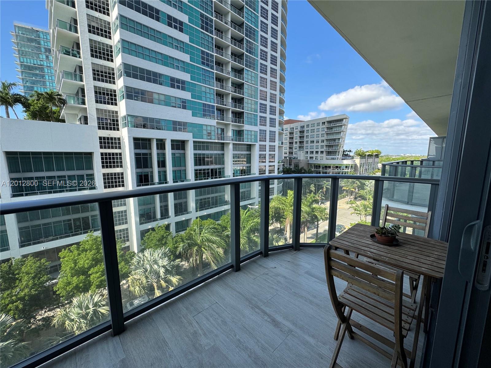 A modern kitchen features wood-grain cabinetry, stainless steel appliances, and light-colored tile flooring — 121 NE 34th St # L601, Miami FL 33137, MIAMI, FL