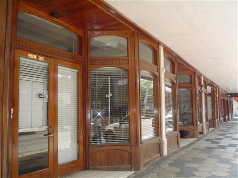 A row of storefronts with wooden frames and glass windows lines a tiled outdoor walkway — 1624-1630 E 7TH AVENUE, TAMPA, FL
