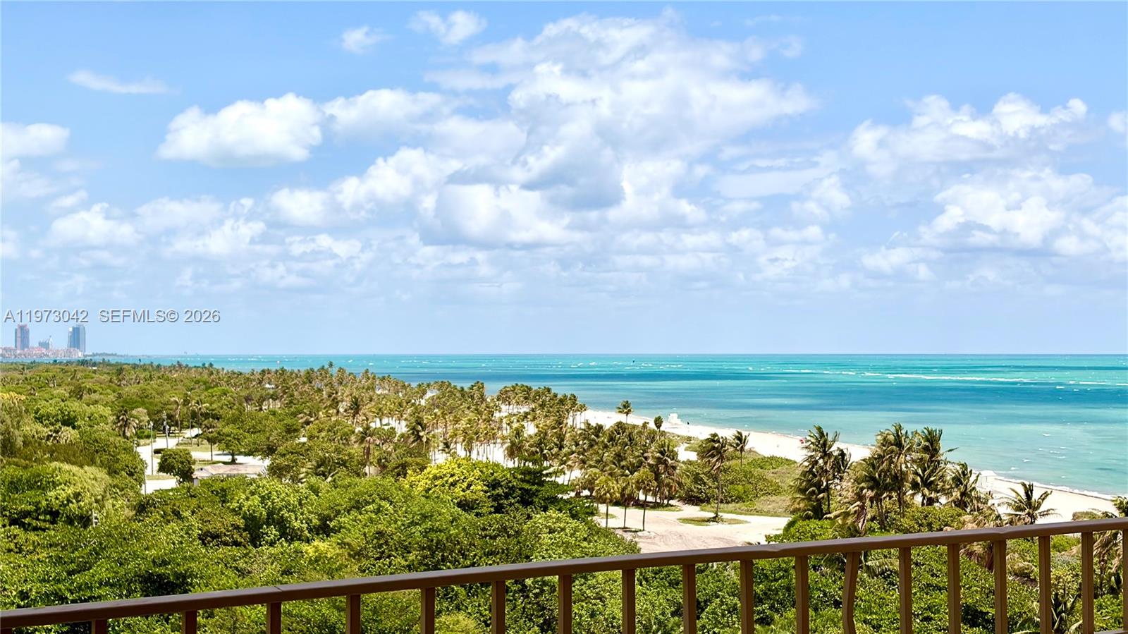 A view of a sandy beach and ocean from a balcony with a railing — 177 Ocean Lane Dr # 1008, Key Biscayne FL 33149, KEY BISCAYNE, FL