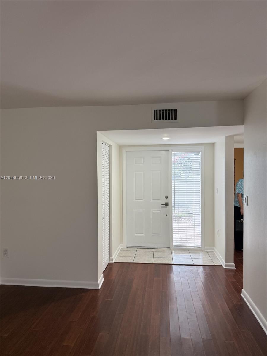An entryway features a white front door, tiled floor, and dark wood laminate flooring — 9686 SW 138th Ave # 9686, Miami FL 33186, MIAMI, FL