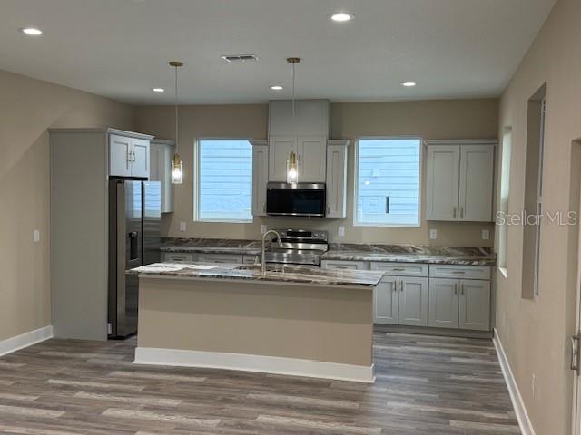 A kitchen features light gray cabinets, a central island, and stainless steel appliances — 5010 E 32ND AVENUE UNIT 2, TAMPA, FL