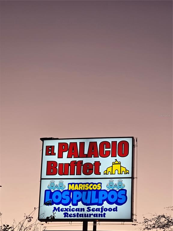 A large, illuminated restaurant sign stands against a twilight sky — 909 W VINE STREET, KISSIMMEE, FL