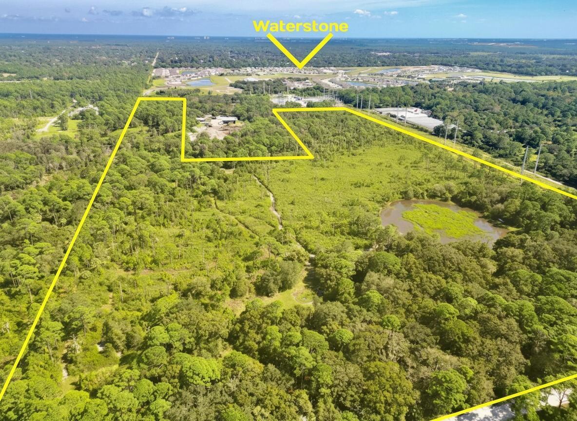An aerial view shows a large, undeveloped wooded lot with a small pond and yellow outline — 5562 Russakis Road, Fort Pierce FL 34951, FORT PIERCE, FL