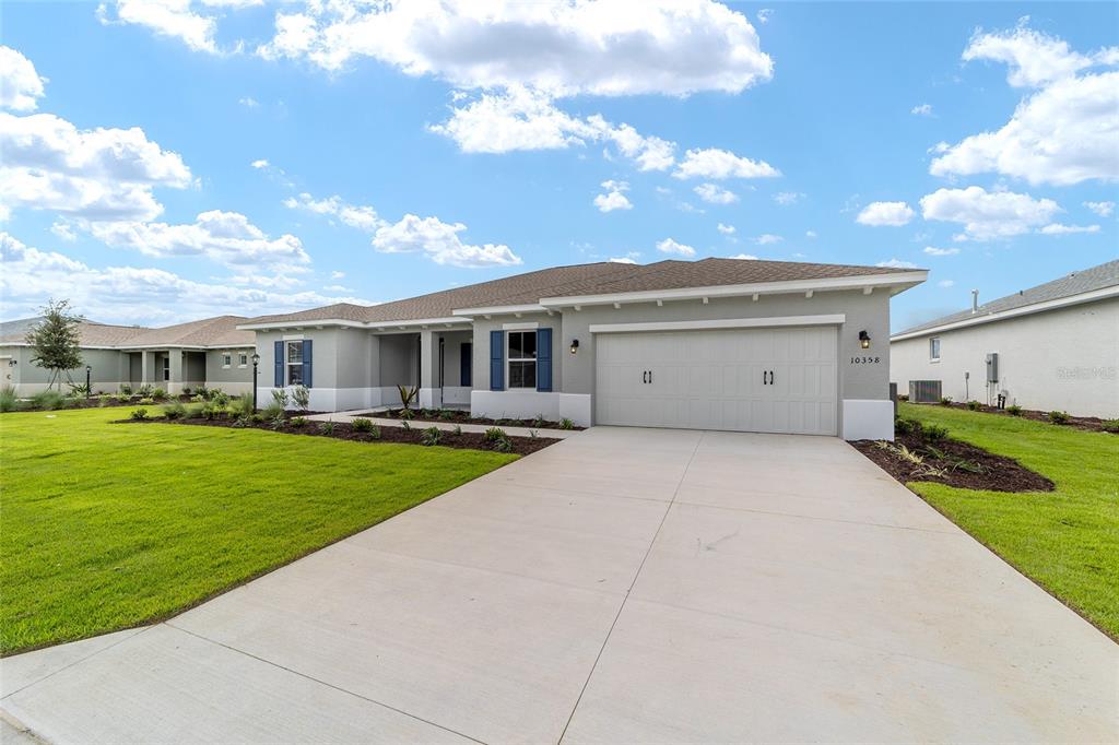 A single-story house with a gray exterior, blue shutters, and a two-car garage — 10358 SW 105TH COURT, OCALA, FL