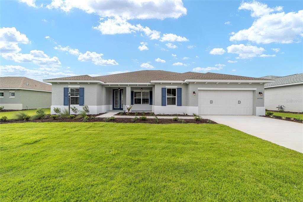 A single-story house with a gray exterior, blue shutters, and a two-car garage — 10358 SW 105TH COURT, OCALA, FL