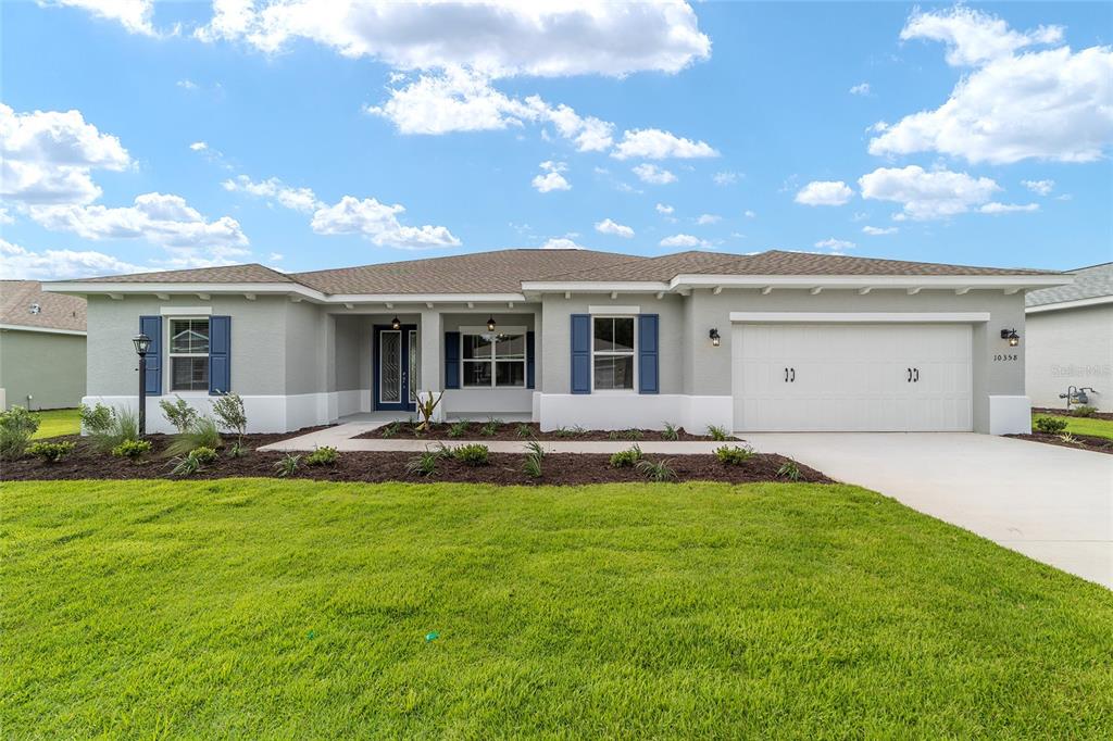 A single-story house with a gray exterior, blue shutters, and a two-car garage — 10358 SW 105TH COURT, OCALA, FL