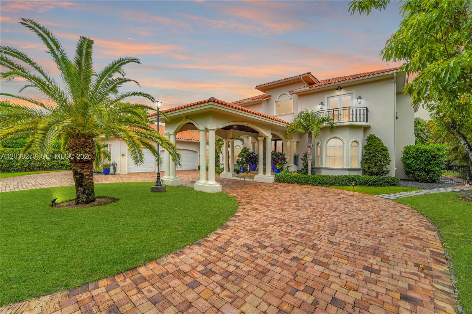 A two-story stucco house with a brick driveway, porte-cochère, and a palm tree in front — 11111 SW 77th Ave, Pinecrest FL 33156, PINECREST, FL