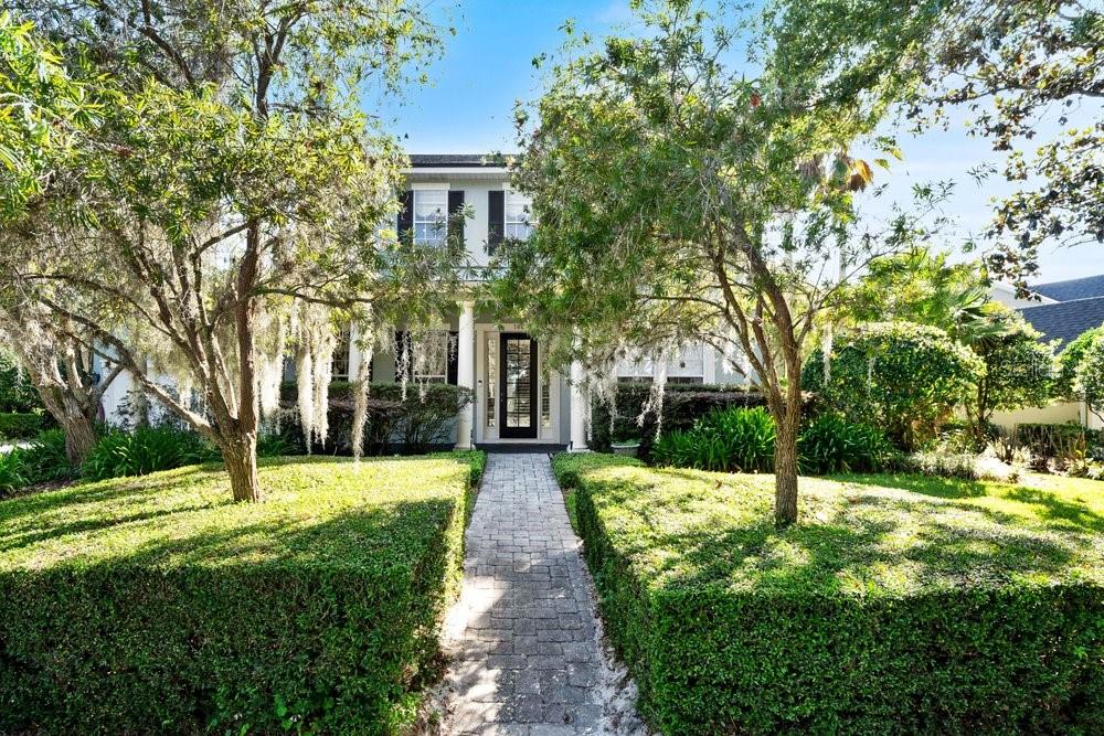 A two-story house with a paved walkway leading to the front door, framed by trees — 106 CALLAWAY COURT, DELAND, FL