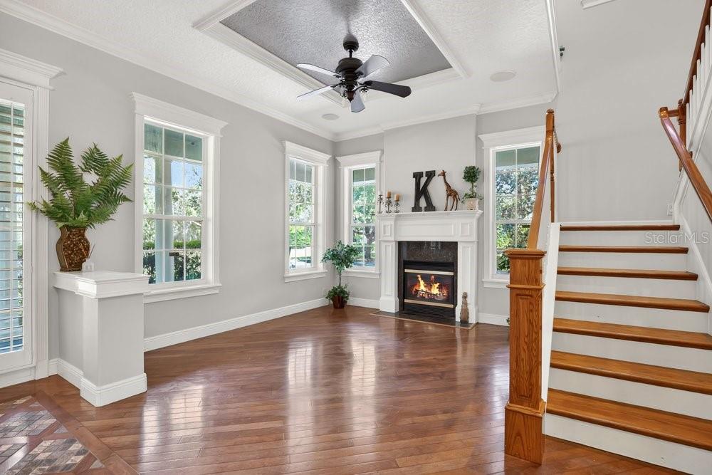 A living room features hardwood floors, a fireplace with a mantel, and a staircase — 106 CALLAWAY COURT, DELAND, FL