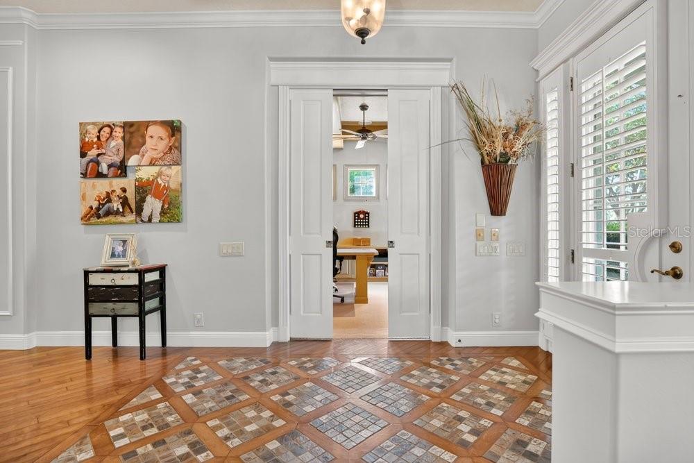 A foyer with hardwood floors, a tiled inlay, and double sliding doors leading to an office — 106 CALLAWAY COURT, DELAND, FL