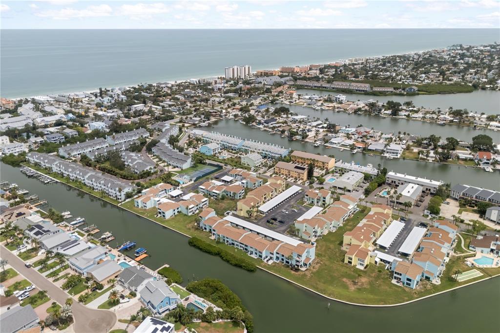 An aerial view of a coastal residential neighborhood featuring multi-family buildings and canals — 1 WINDRUSH BOULEVARD UNIT 63, INDIAN ROCKS BEACH, FL