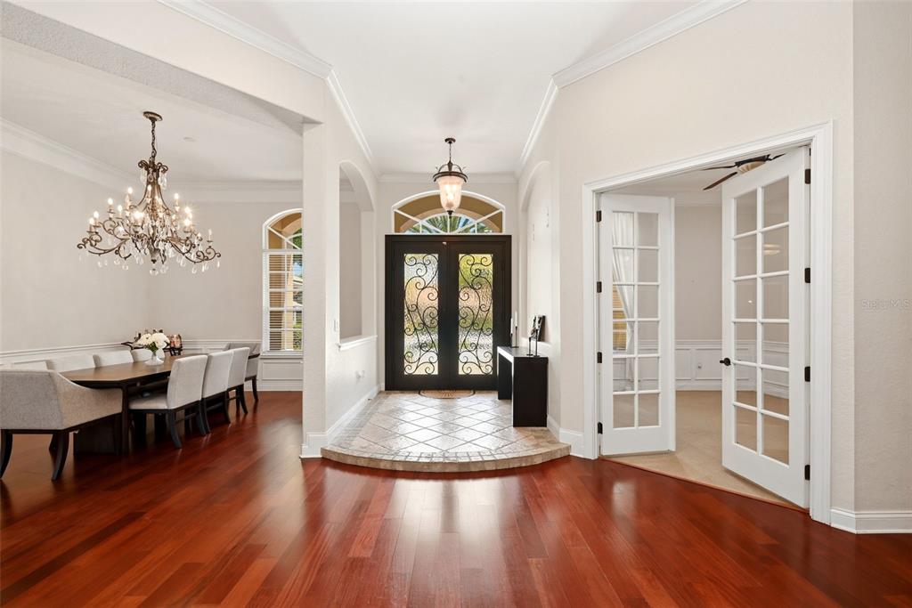 A two-story house with a green tile roof and a circular driveway with a palm tree — 9119 BALMORAL MEWS SQ, WINDERMERE, FL