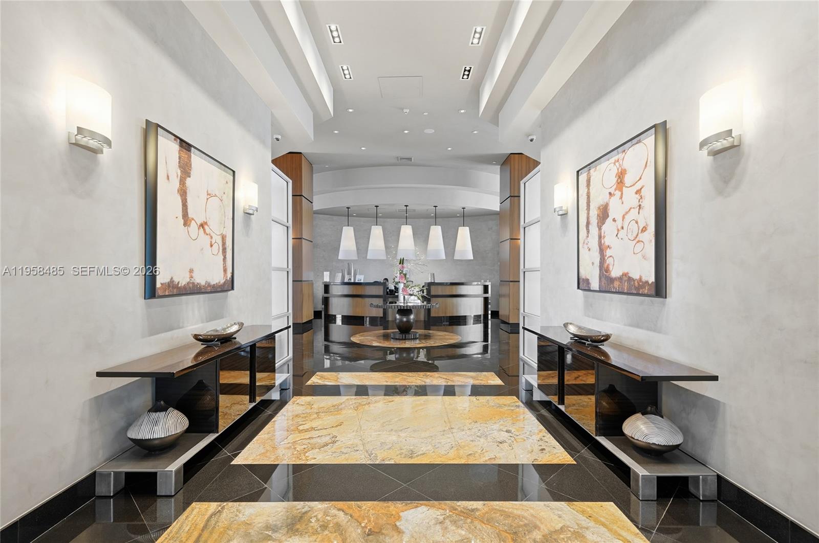 A symmetrical lobby features a reception desk, marble floor inlays, and two matching wall paintings — 3101 S OCEAN # 1802, Hollywood FL 33019, HOLLYWOOD, FL
