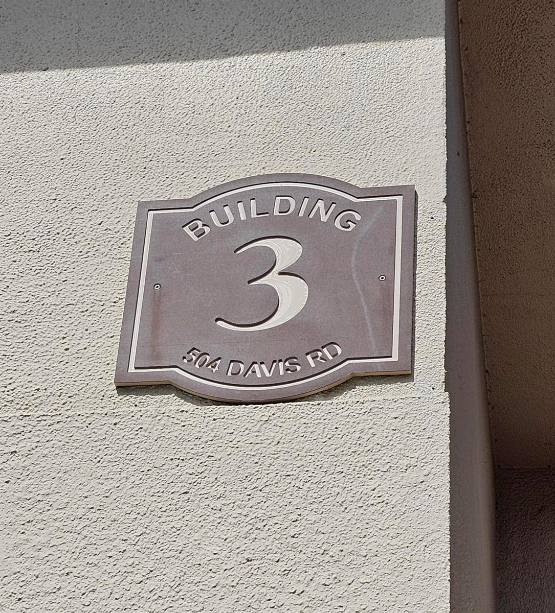 A brown metal sign labeled Building 3 is mounted on a textured beige exterior wall — 504 Davis Road # 96, Palm Springs FL 33461, PALM SPRINGS, FL