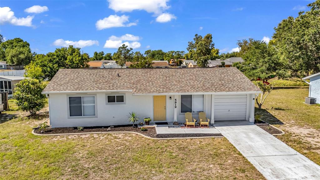 A single-story house with a white exterior, yellow front door, and an attached garage — 5919 HOBHILL AVENUE, NORTH PORT, FL