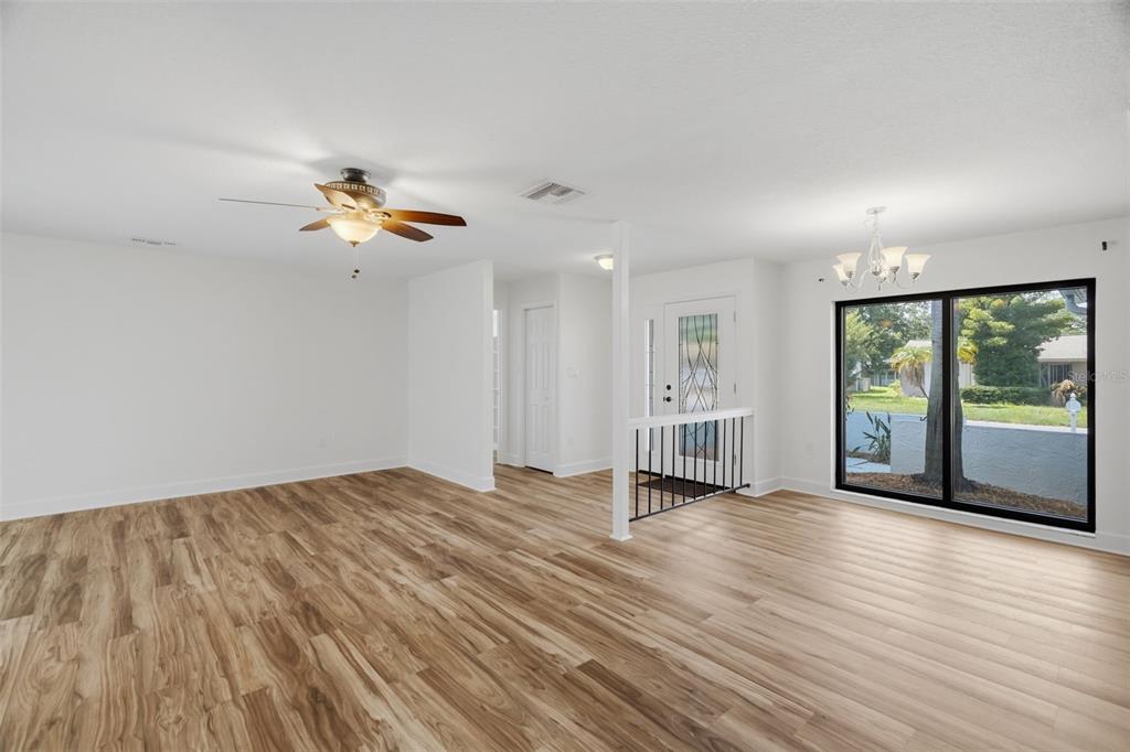A bright living area features light wood-look flooring, a ceiling fan, and a front entryway — 104 NESTLEBRANCH DRIVE, SAFETY HARBOR, FL