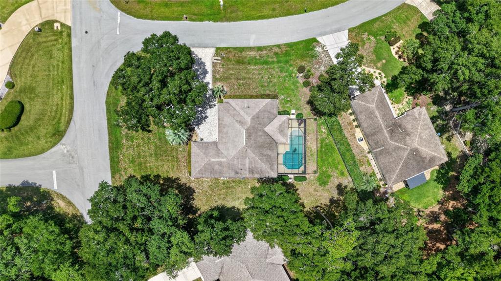 An aerial view shows a house with a screened-in pool and surrounding wooded landscape — 19331 SW 100TH LOOP, DUNNELLON, FL