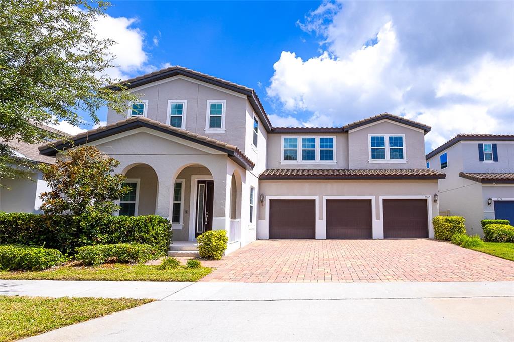 A two-story suburban house with a three-car garage and a paved driveway — 9567 MEADOW HUNT WAY, WINTER GARDEN, FL